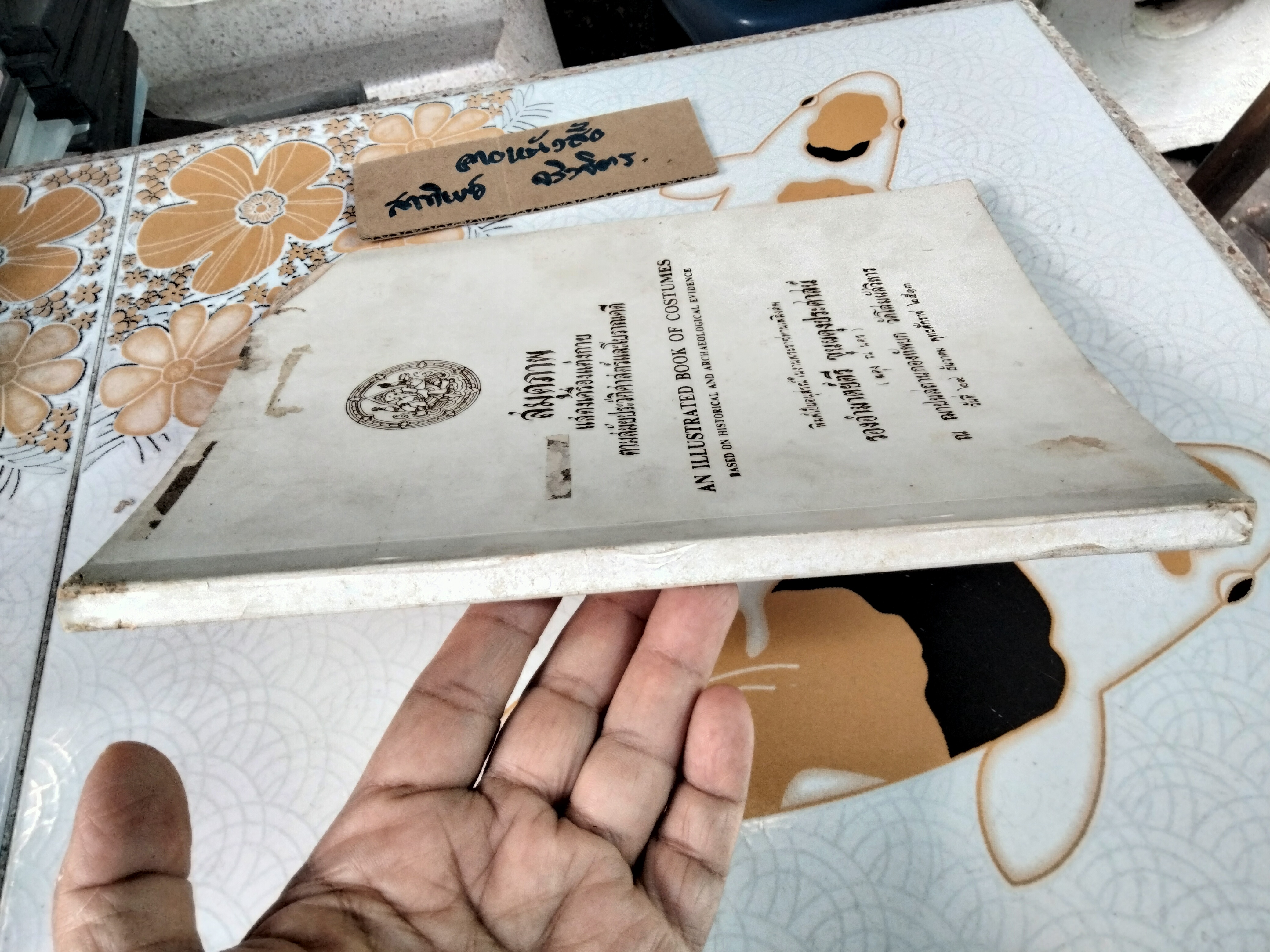 สมุดภาพ แสดงเครื่องแต่งกาย ตามสมัยประวัติศาสตร์และโบราณคดี โดย กรมศิลปากร (หนังสือมีตำหนิ ปกหน้าและมุมหน้าแรกๆ แหว่งหายไป)