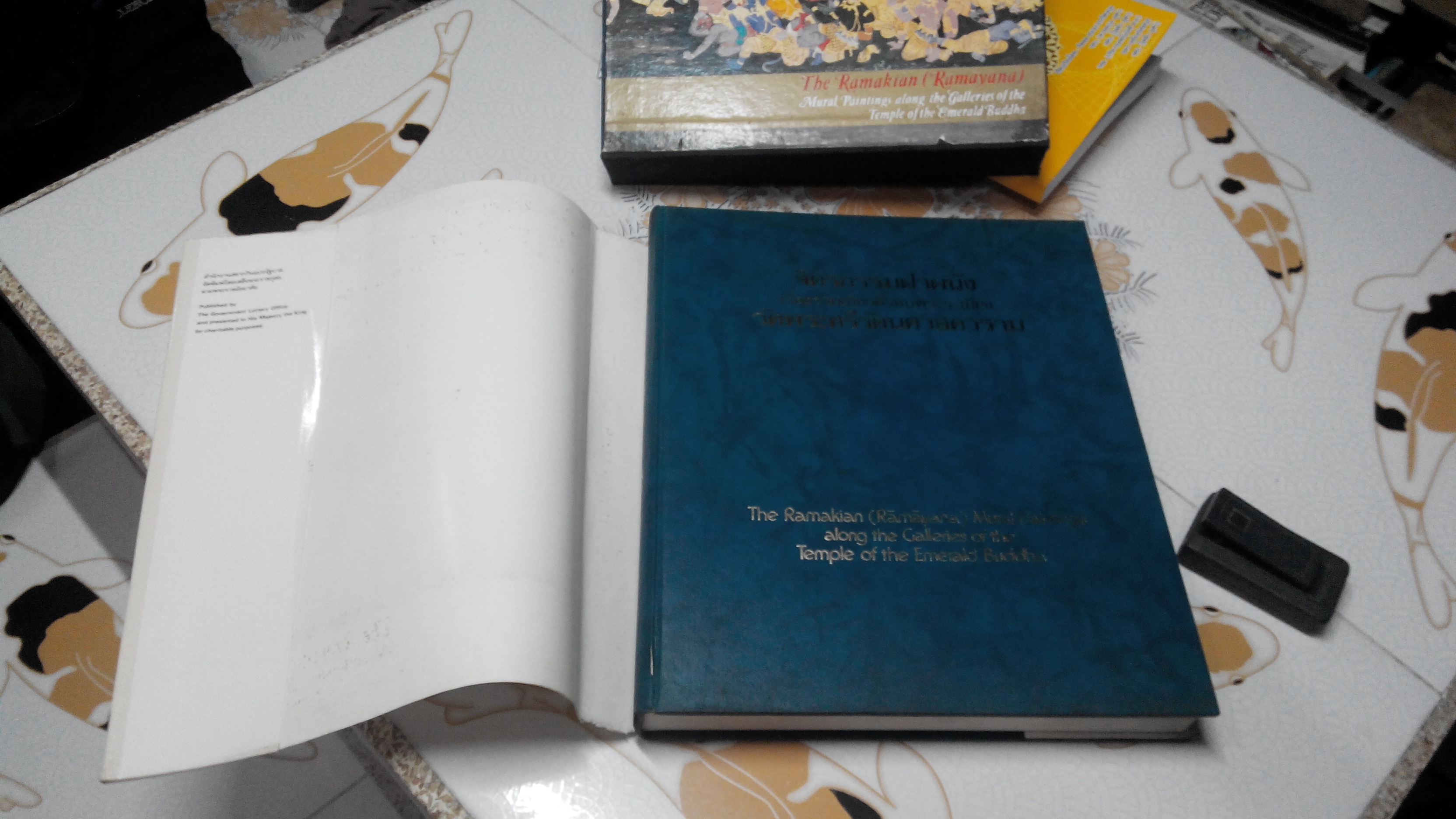 จิตรกรรมฝาผนังเรื่องรามเกียรติ์ รอบพระระเบียง วัดพระศรีรัตนศาสดาราม ( The Ramayana - Mural paintings along the galleries of the temple of The Emerald Budha ) หนังสือปกแข็ง มีใบหุ้มปก พร้อมกล่อง